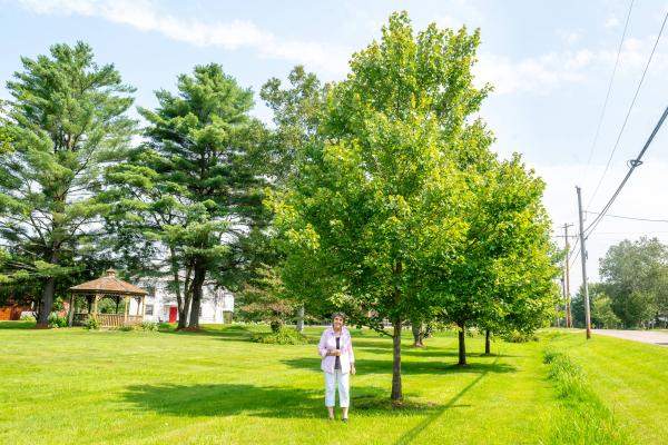 Jane Brown in Waterbury standing next to a tree planted through a UCF grant